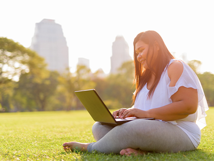 Woman sitting in park on computer