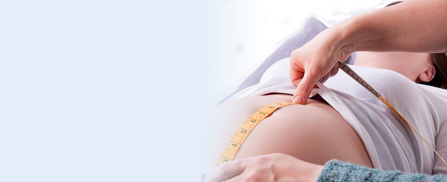 Midwife measuring pregnant belly