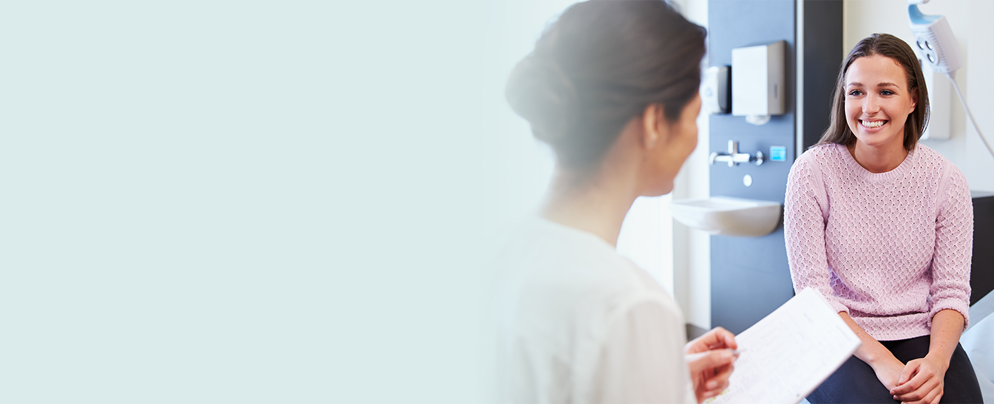 Young woman talking with nurse.