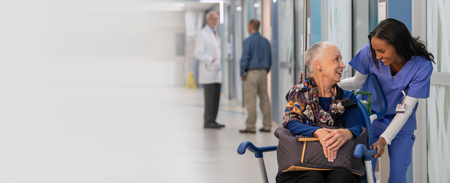 Nurse talking with patient in wheelchair.