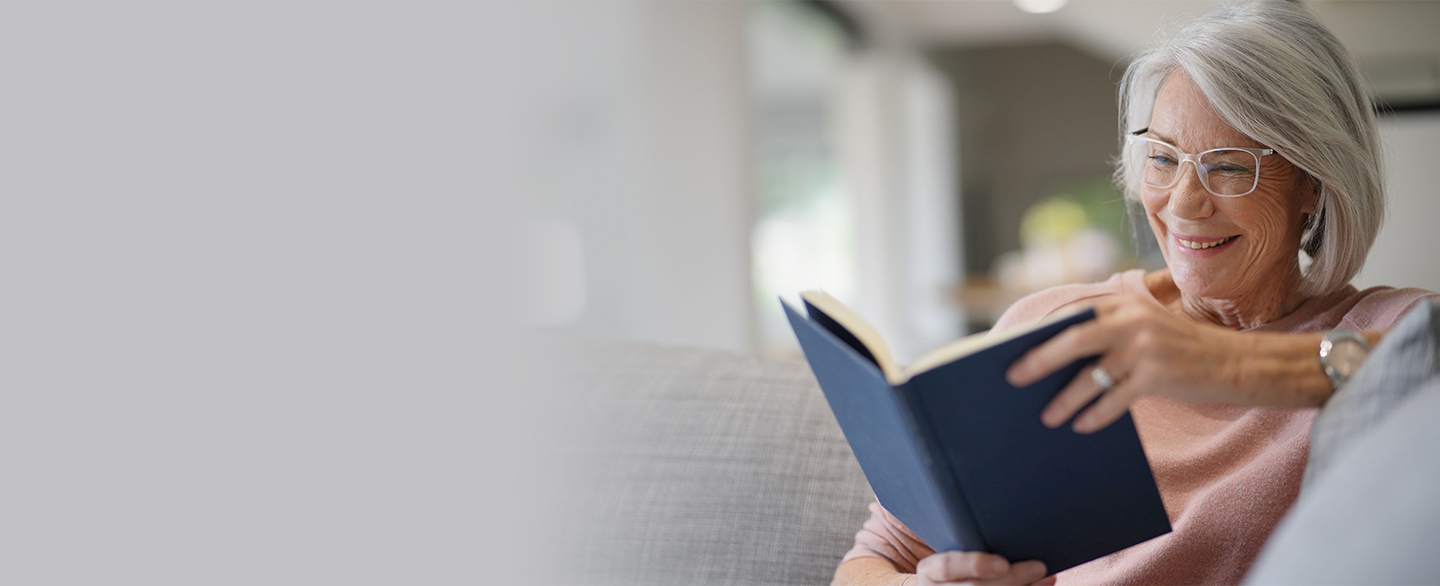 Woman in glasses reading a book.