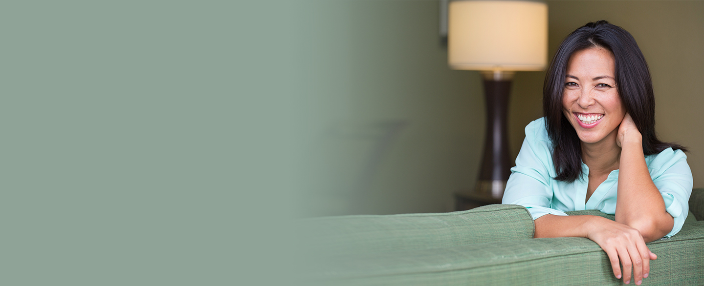 Woman sitting on couch smiling.