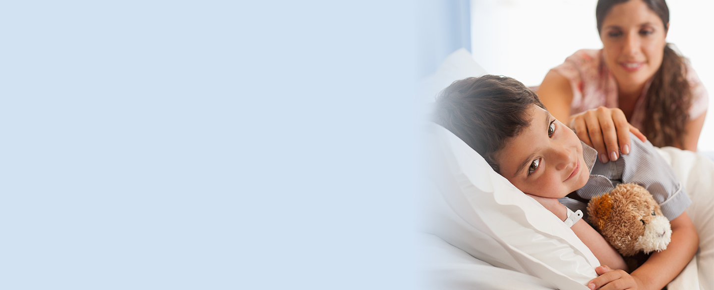 Young boy laying in hospital bed.