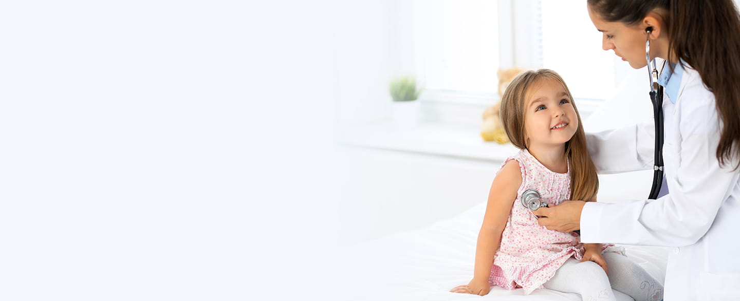 Little girl looking up at doctor smiling.