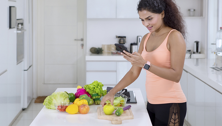 Woman using smart phone in the kitchen.