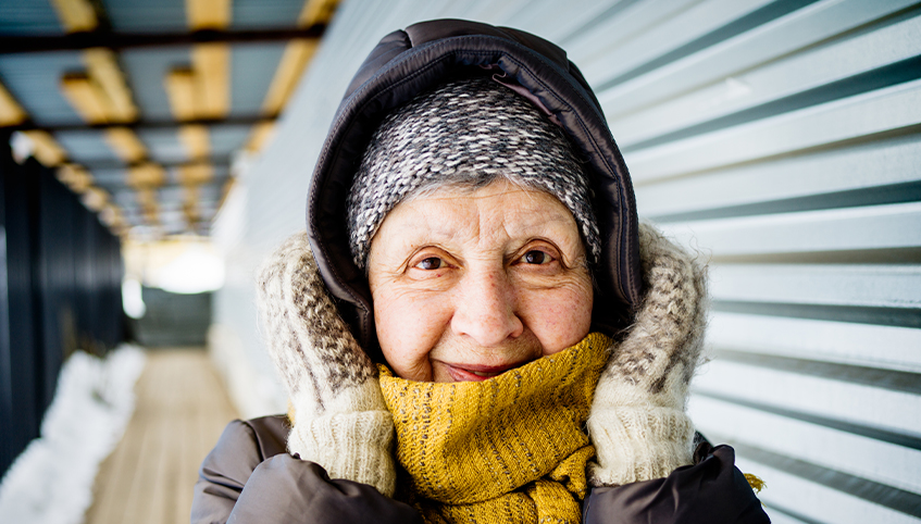 Elderly woman wearing layers of warm clothes in the middle of winter