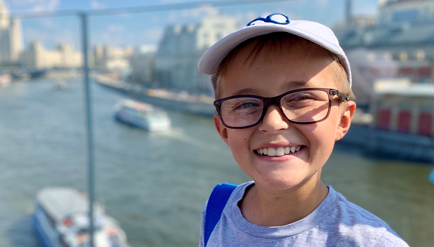 Roman Volkov smiling in front of a body of water with boats