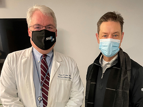 Dr. Ault standing with Toby Cook, masked