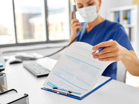 Nurse on the phone looking through patient chart