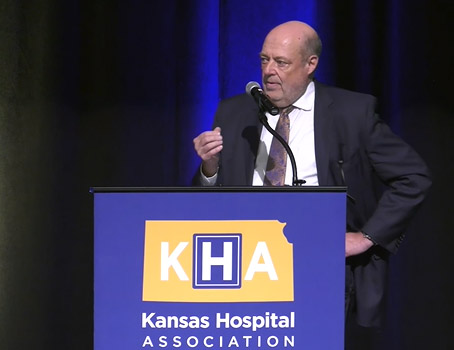 Bob Page, CEO and president, The University of Kansas Health System, speaking from a podium at the Kansas Hospital Association luncheon.