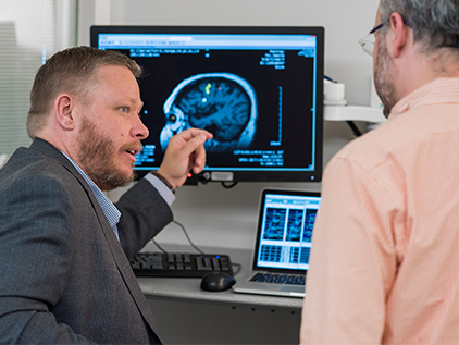 Doctors looking at brain scans on computer.