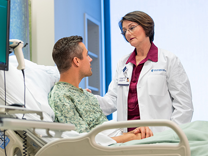 Doctor visiting with patient in hospital.