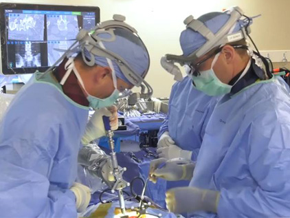 Surgeons performing minimally-invasive, robot-assisted surgery.