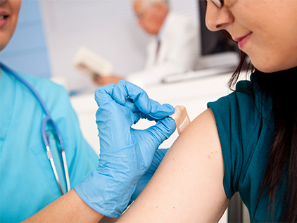Nurse putting bandaid on patient after receiving a shot.