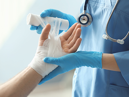 Nurse wrapping patient's hand.