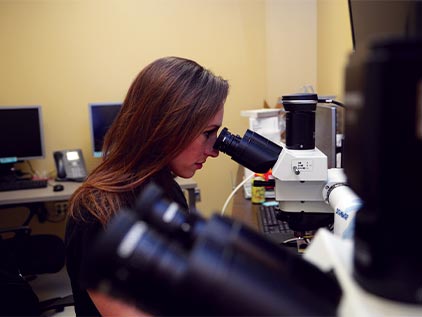Dr. Tate looking into microscope