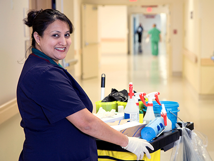 Custodial worker in hospital hallway.