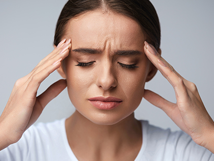 Girl holding her head with a headache. 