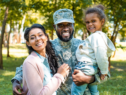 Military family outside smiling.