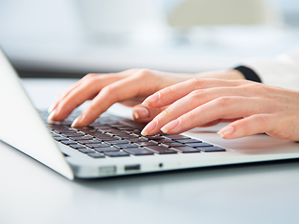 Person searching the internet on a laptop.