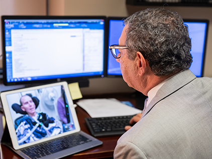 Doctor interacting with ALS patient using telehealth.