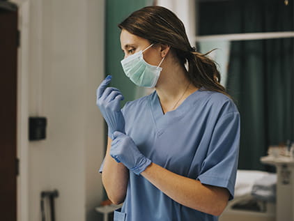 Nurse wearing mask and gloves.