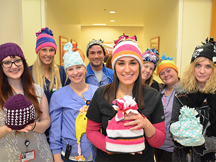 Group of nurses holding hats for Caps for Cancer.