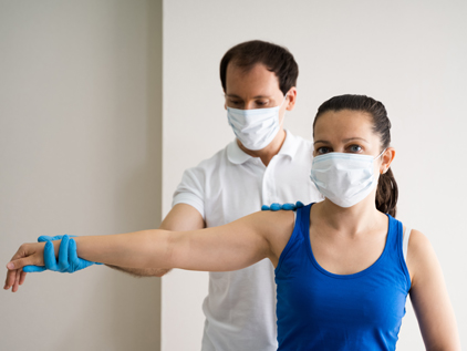 Doctor inspecting shoulder of female athlete