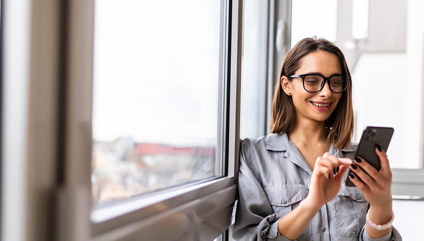 Smiling woman using her phone