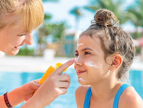 Woman applying sun screen to child's face