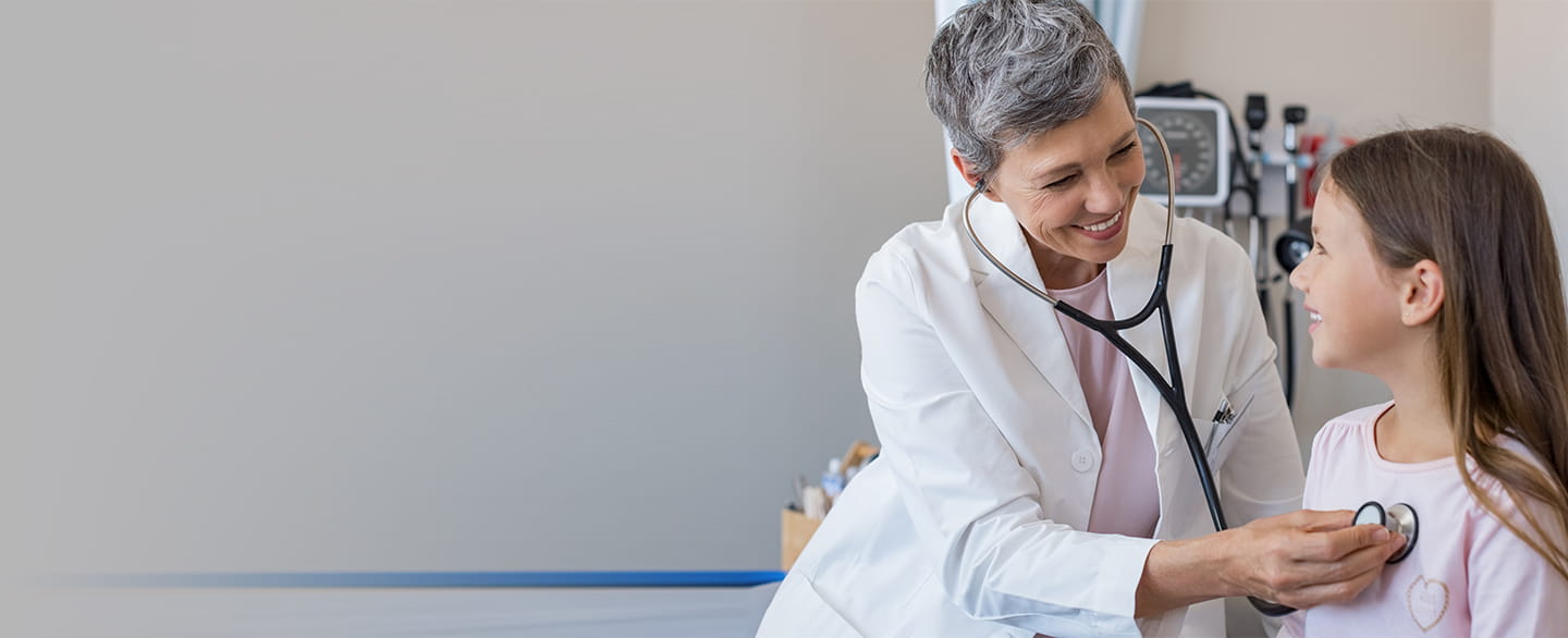 Pediatrician checking patient's heartbeat.