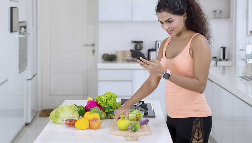 Woman using smart phone in the kitchen.