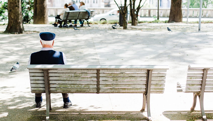 Man sitting alone on a park bench.
