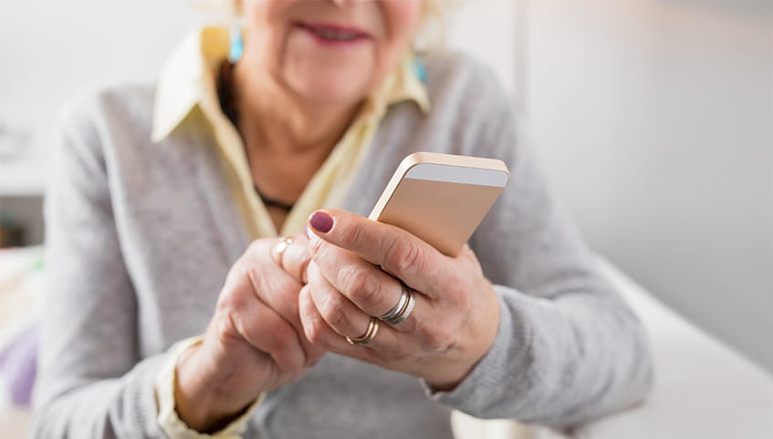 Older woman using cell phone.