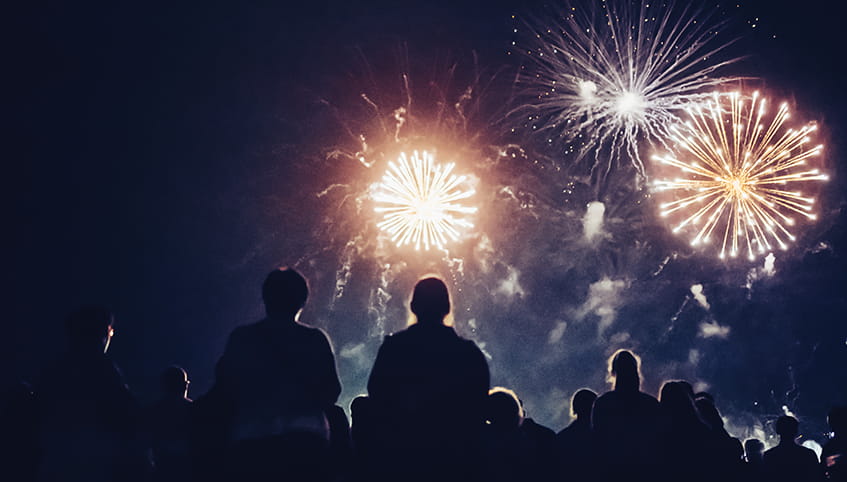 People watching a fireworks show at night
