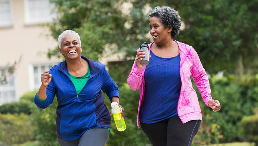 Two ladies exercising outside. 