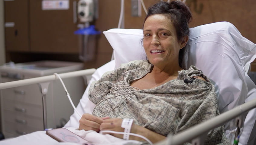 Christina in hospital bed smiling