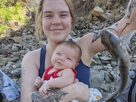 Abbi Winters smiling, holding her son