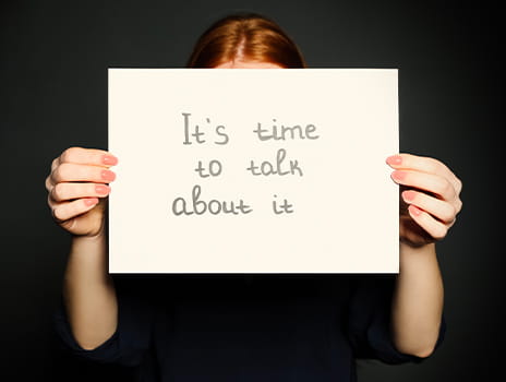 Person holding sign saying, "It's time to talk about it"