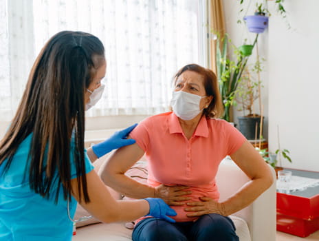 Woman with gallbladder pain being consulted by a healthcare worker