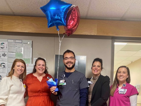 Mayson Lane, holding star shaped balloons, stands in the middle of nursing leaders after receiving the RFTS scholarship.