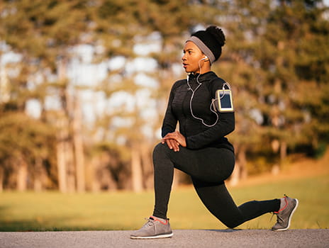Female athlete stretching while exercising outdoors