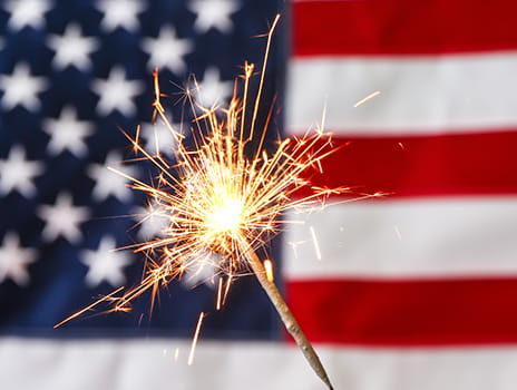 Sparkler in front of the flag of the United States of America