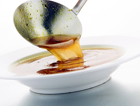 Ladling broth into a bowl.