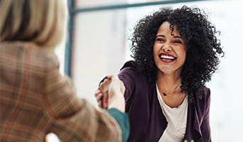 Two women shaking hands.