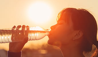 Drinking water to stay hydrated in the sun