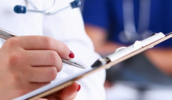 Doctor writing on a clipboard