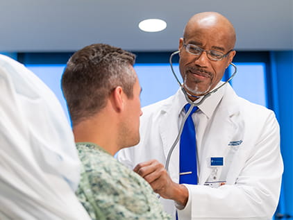 Doctor checking patient's heartbeat.