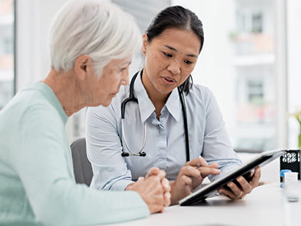 doctor looking at a tablet with a patient