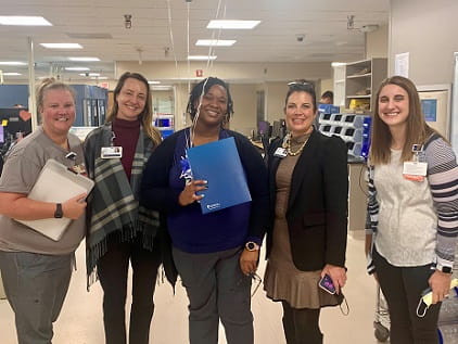 Lisa-Marie Uketui, holding blue folder, stands with nursing leaders to celebrate her RFTS scholarship.